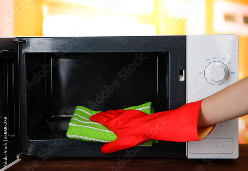 Hand with microfiber cleaning  microwave oven,