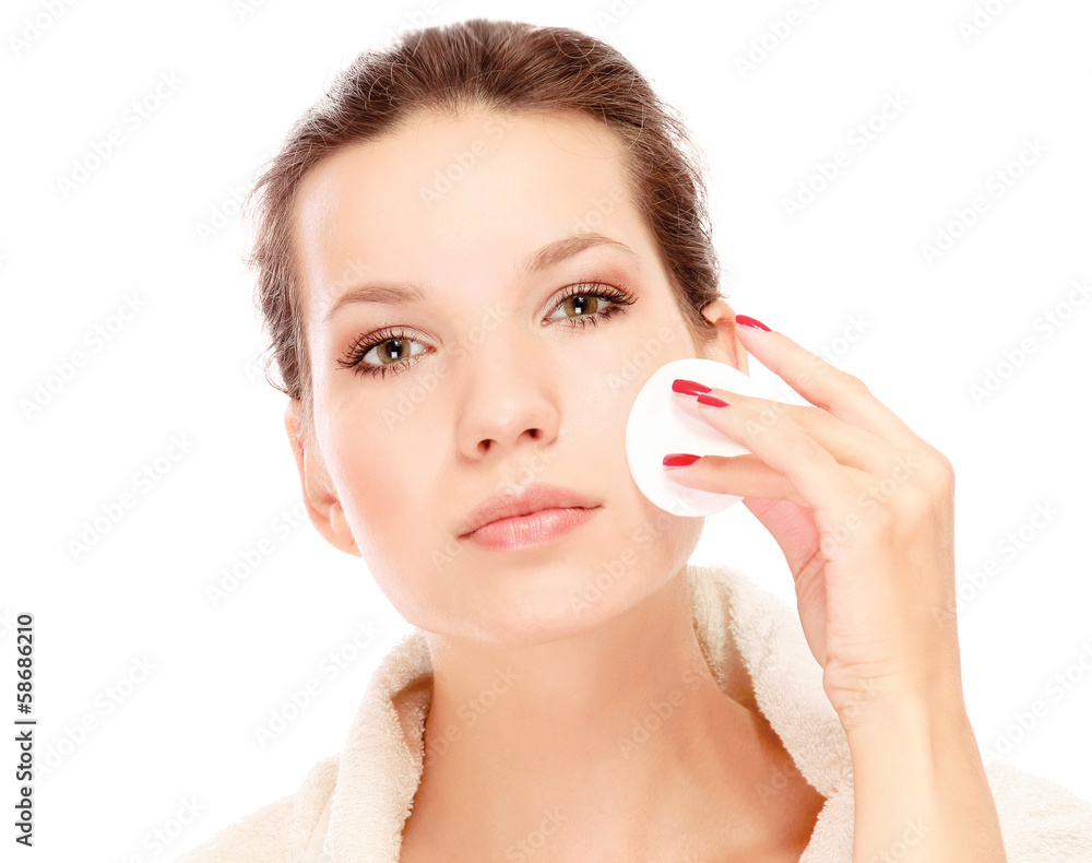 Portrait of young woman with cotton swab cleaning her face