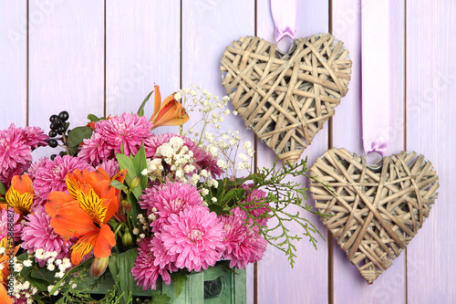 Fototapeta Naklejka Na Ścianę i Meble -  Flowers composition in crate with decorative hearts