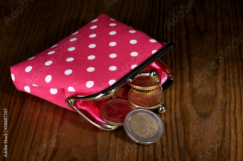 Pink purse with money on table close-up