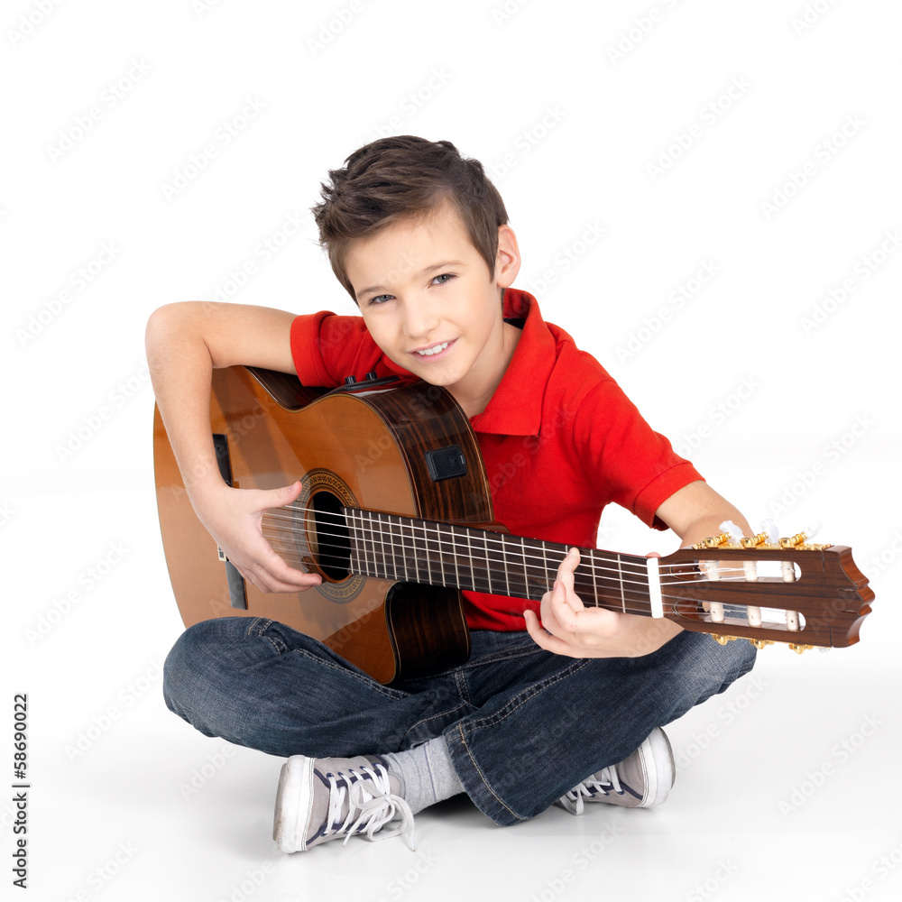 Fototapeta premium happy boy is playing on acoustic guitar