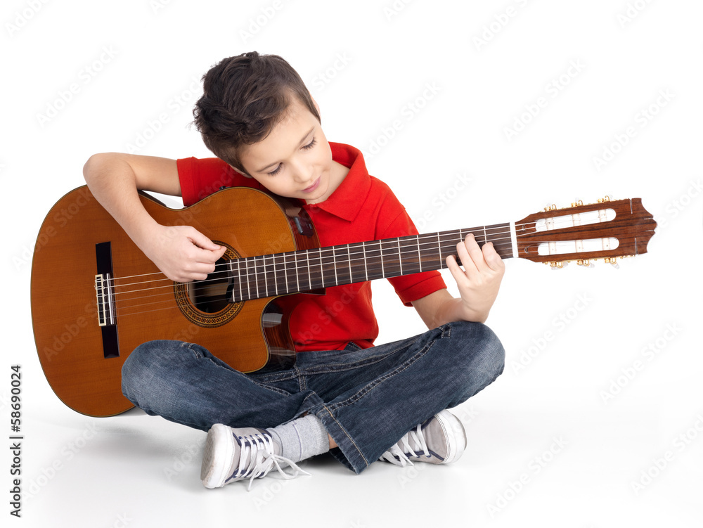 Fototapeta premium Smiling boy is playing the acoustic guitar