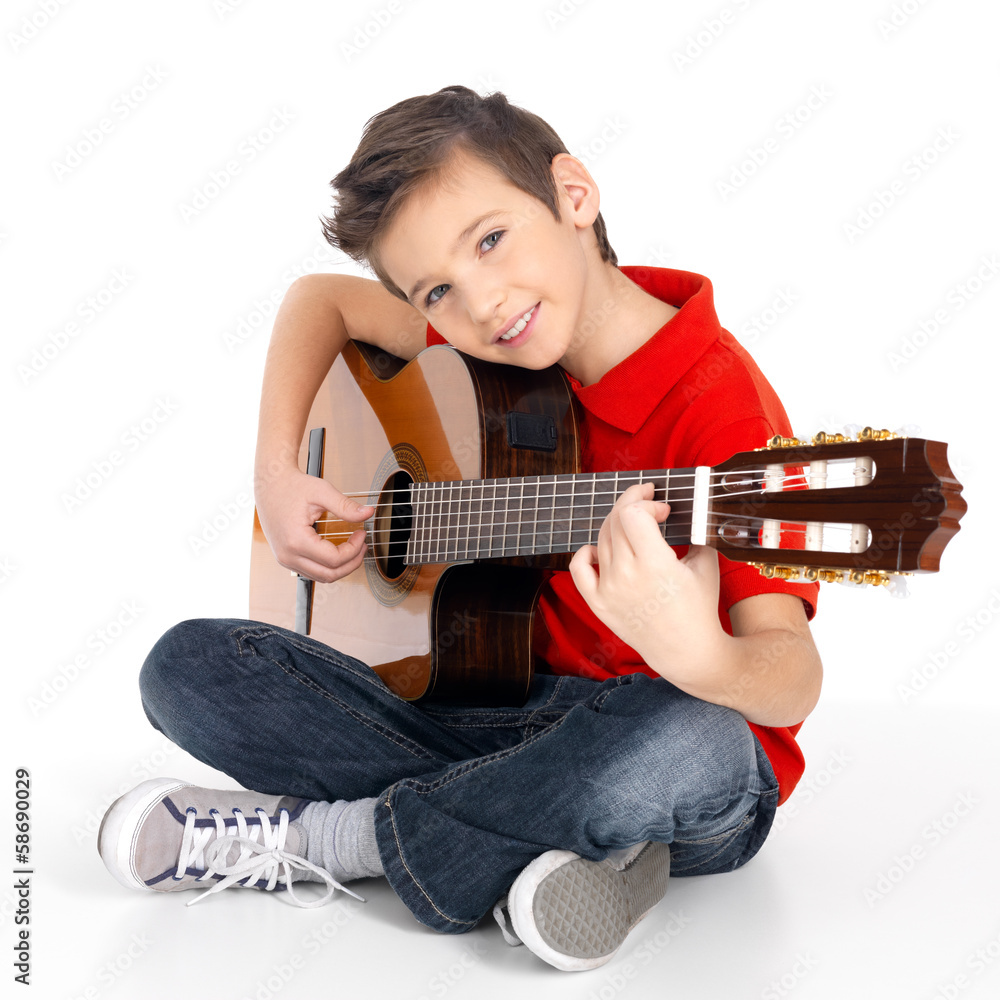 Fototapeta premium happy boy is playing on acoustic guitar