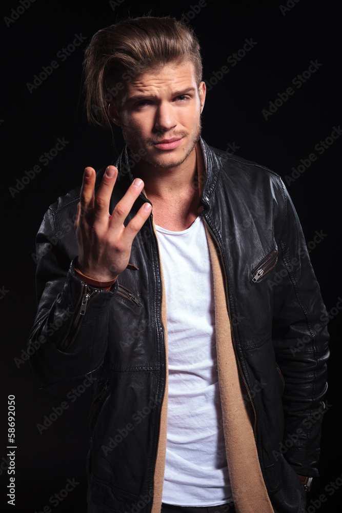 Naklejka premium young man in leather jacktes asking you what do you want