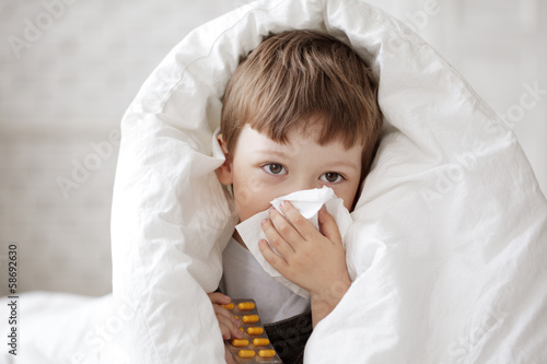 boy wipes his nose with a tissue