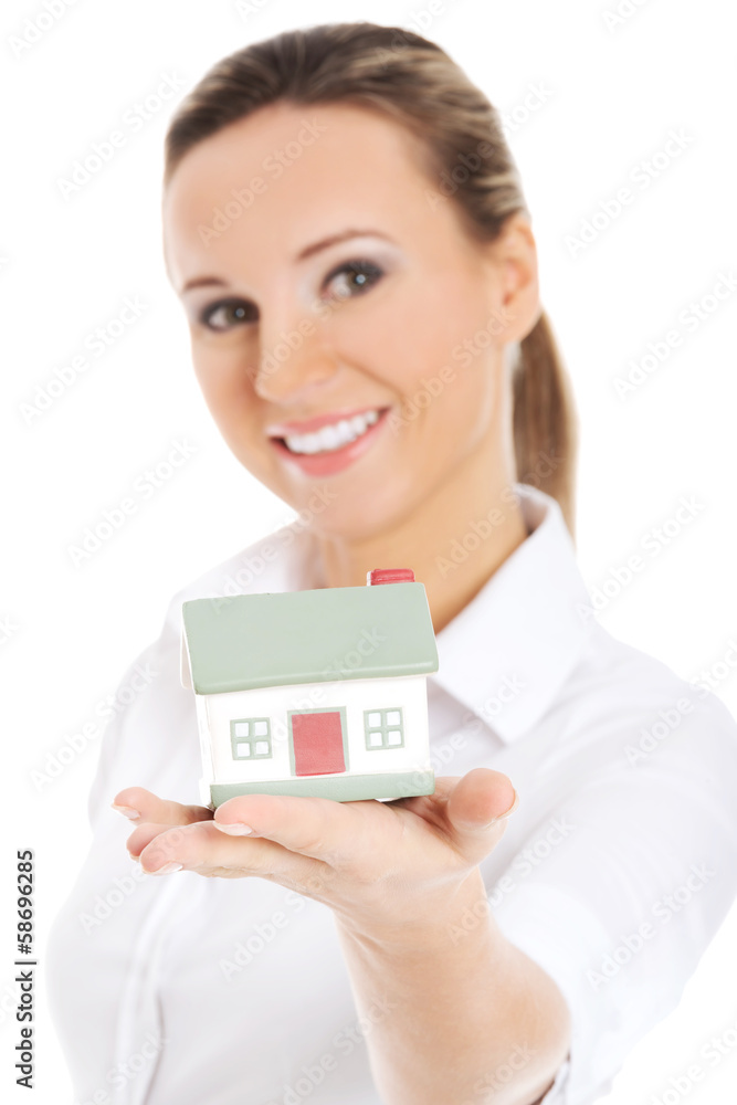 Young business woman holding a house on her palm. Young business woman holding a house on her palm.