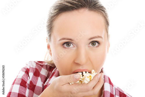 Young casual woman eating popcorn.