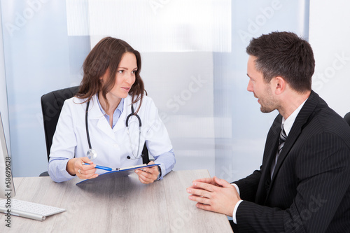 Female Doctor Looking At Businessman