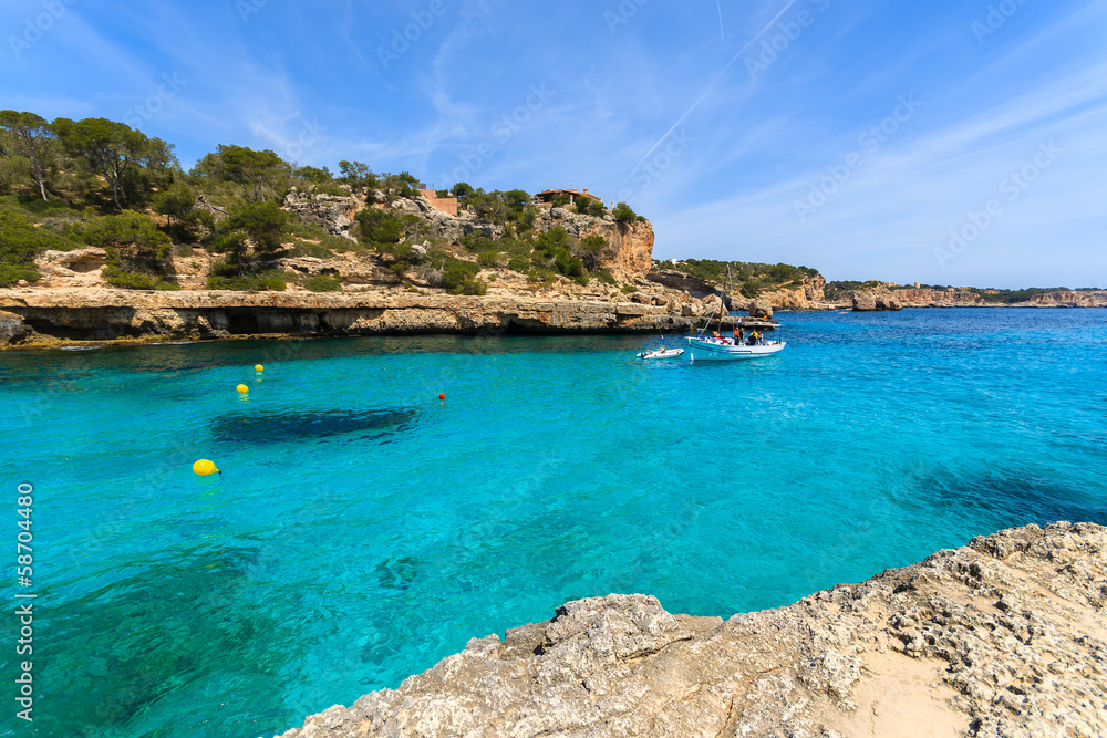 Boat on azure crystal clear sea water, Cala Llombards, Majorca Boat on azure crystal clear sea water, Cala Llombards, Majorca