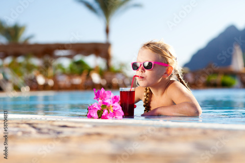 Photography girl drinking coctail in the pool