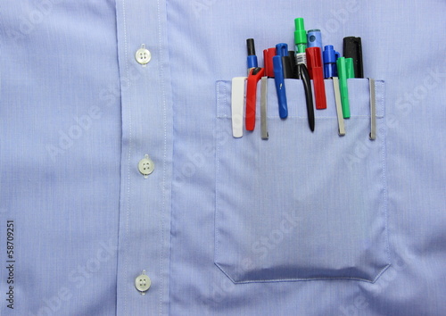 Blue shirt pocket with many different ballpoint pen and bottoms