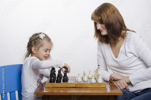Мама учит дочку играть в шахматы