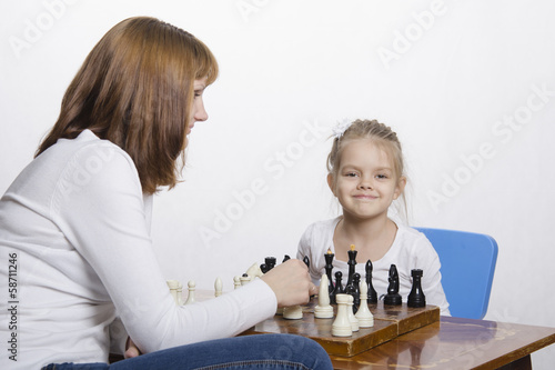 Мама учит дочку играть в шахматы
