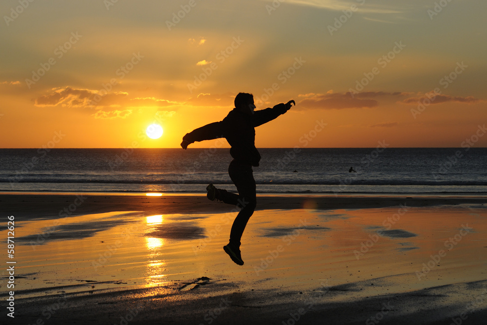 man running on the beach at sunset