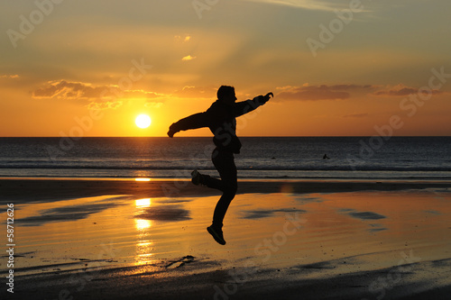 man running on the beach at sunset