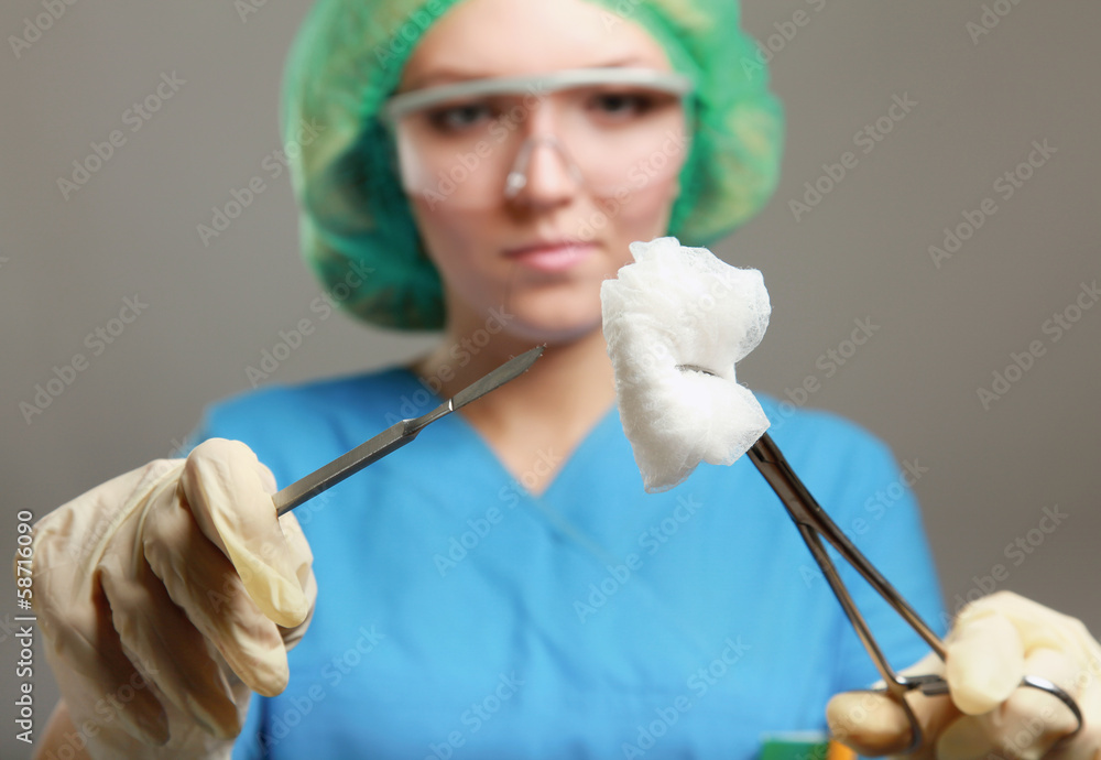 Woman surgeons holding medical instruments in hands Woman surgeons holding medical instruments in hands