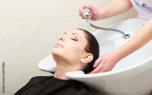 Hairstylist washing woman hair. Hairdressing beauty salon