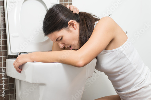 Schilderij op canvas Woman vomiting into the toilet bowl