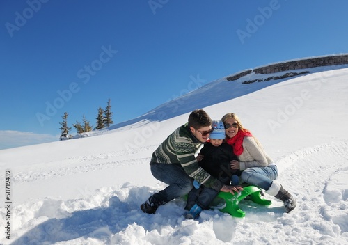 family having fun on fresh snow at winter vacation