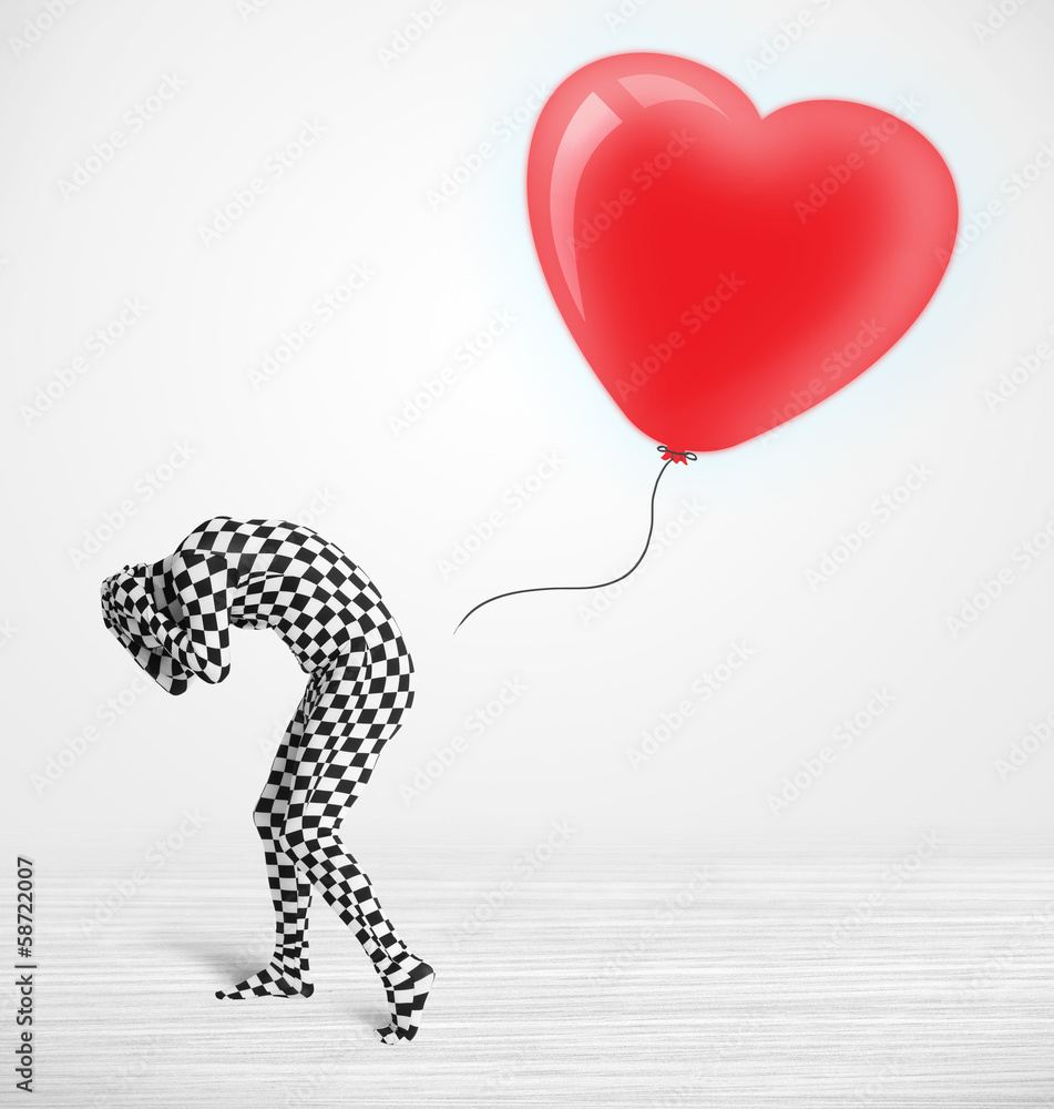 Fototapeta premium Cute guy in morpsuit body suit looking at a balloon shaped heart