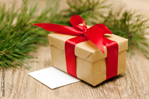 beige gift box with red ribbon in soft focus © olezzo