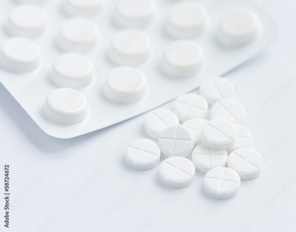 White pills on a white background