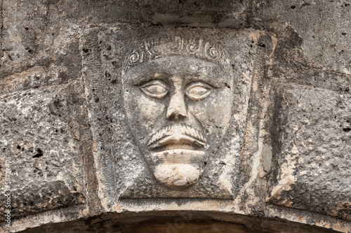 Bas-relief with man s face on ancient house facade in Perast