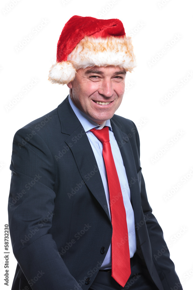 seated old business man wearing a christmas hat is smiling