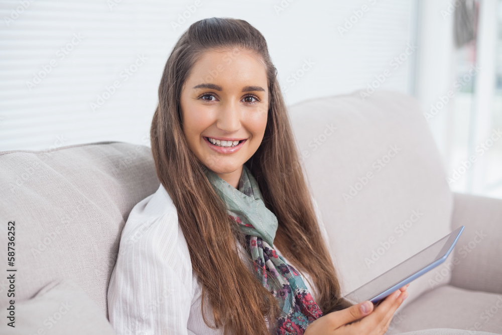 Smiling attractive brunette holding tablet computer Smiling attractive brunette holding tablet computer