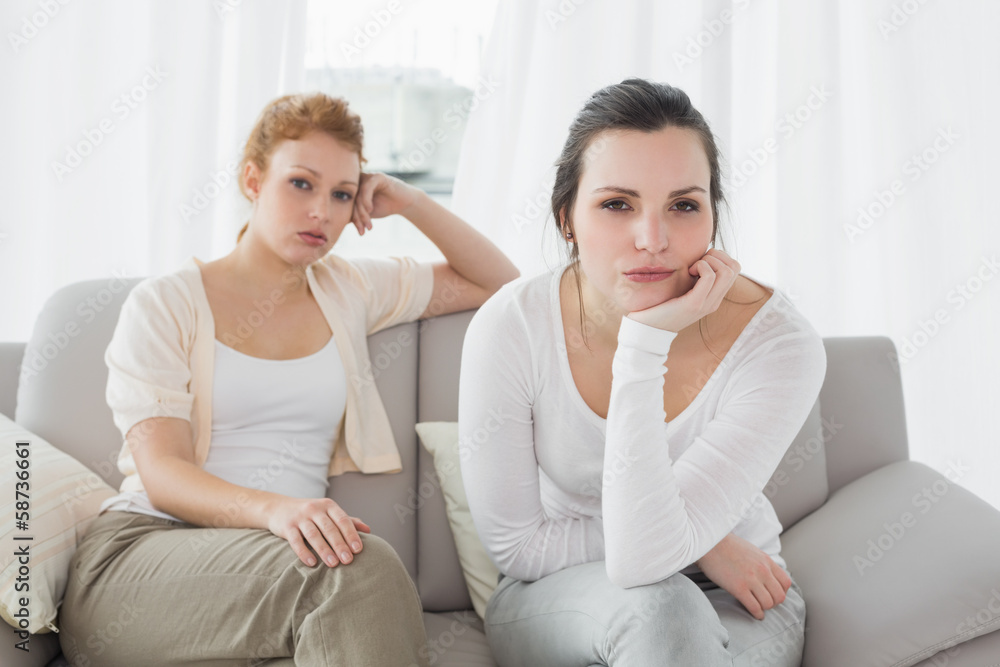 Unhappy friends not talking after argument on the couch Unhappy friends not talking after argument on the couch