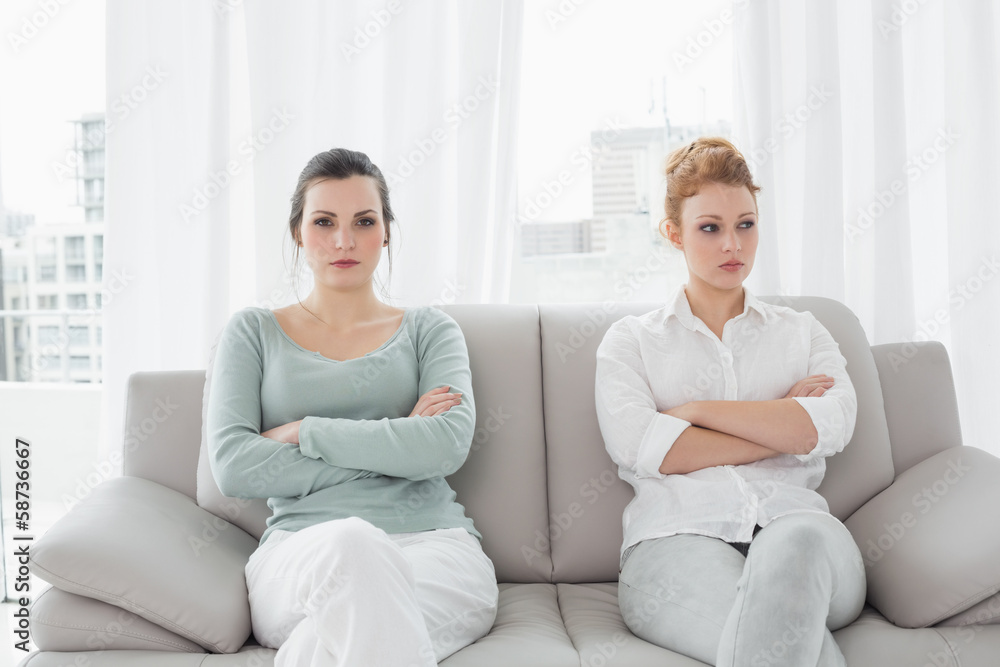 Unhappy friends not talking after argument on the couch Unhappy friends not talking after argument on the couch