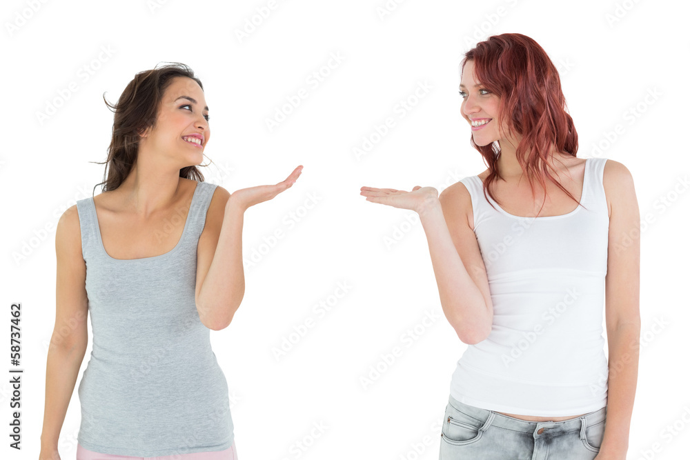 Two happy young female friends holding out their hands Two happy young female friends holding out their hands