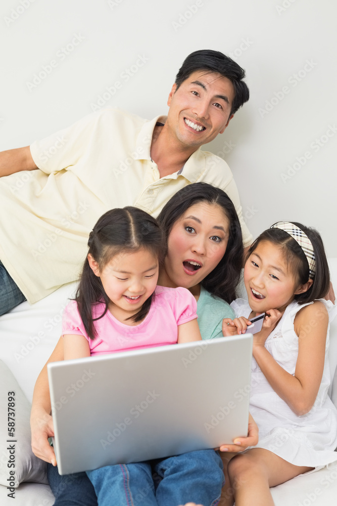 Happy family of four doing online shopping Happy family of four doing online shopping