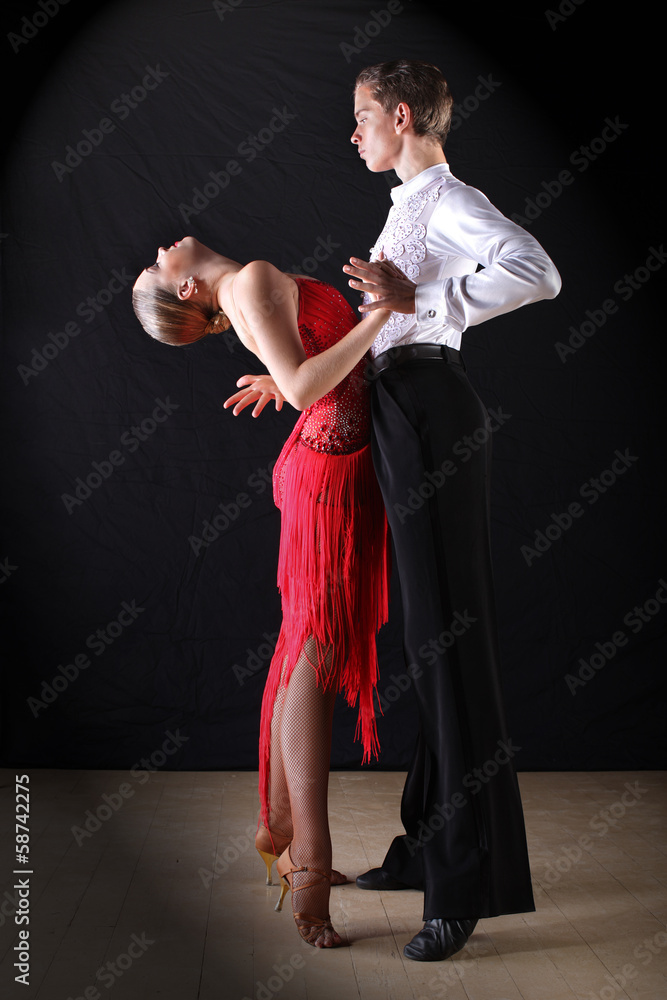 Latino dancers in ballroom against on black Latino dancers in ballroom against on black