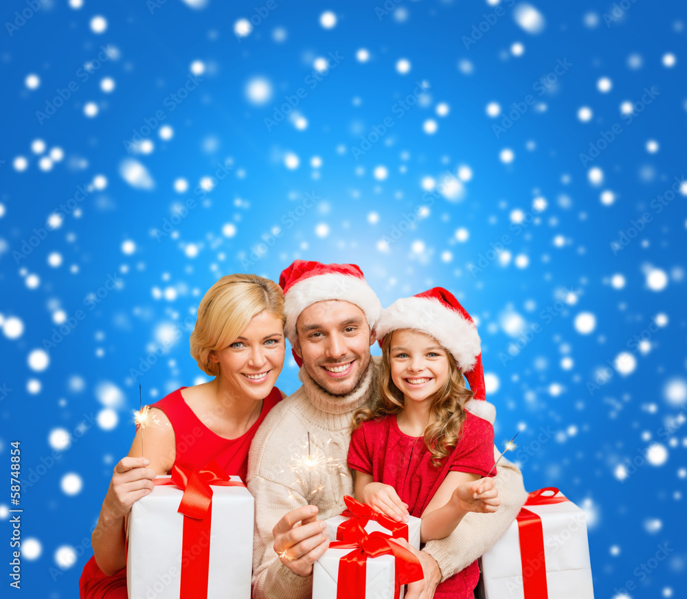 smiling family holding gift boxes and sparkles smiling family holding gift boxes and sparkles