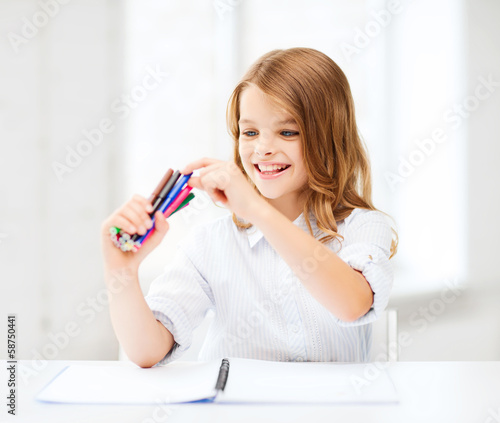 smiling girl choosing colorful felt-tip pen