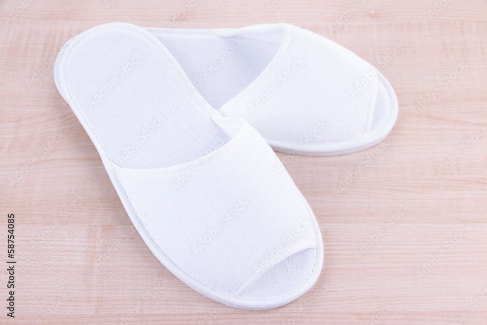 White slippers on wooden background White slippers on wooden background
