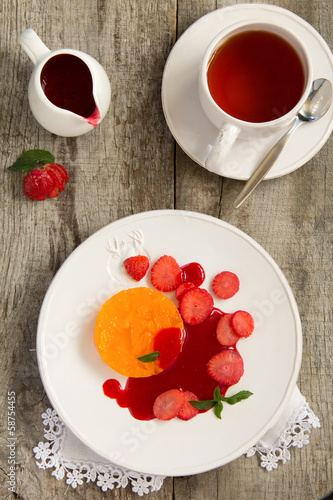 Orange terrine with strawberry sauce and strawberries.