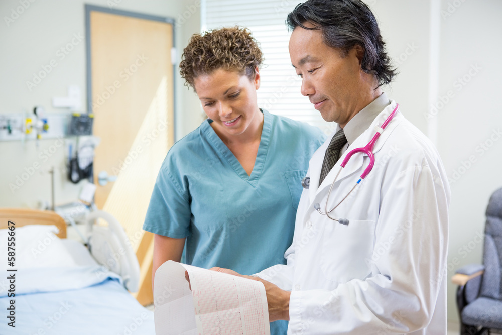 Doctor And Nurse Looking At Fetal Monitor Report In Hospital Doctor And Nurse Looking At Fetal Monitor Report In Hospital