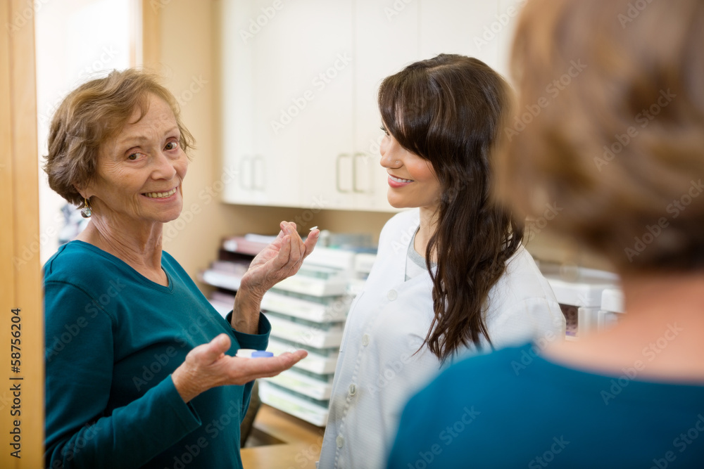 Optometrist Looking At Woman Holding Contact Lens Optometrist Looking At Woman Holding Contact Lens