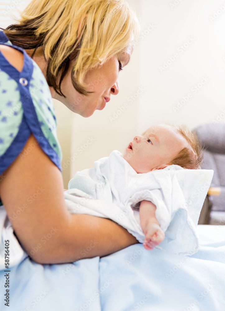 Loving Woman Looking At Cute Babygirl In Hospital Loving Woman Looking At Cute Babygirl In Hospital