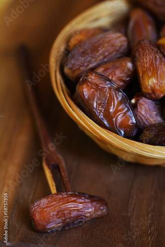 Dates, dried preserved sweet fruits with a wooden fork, serving