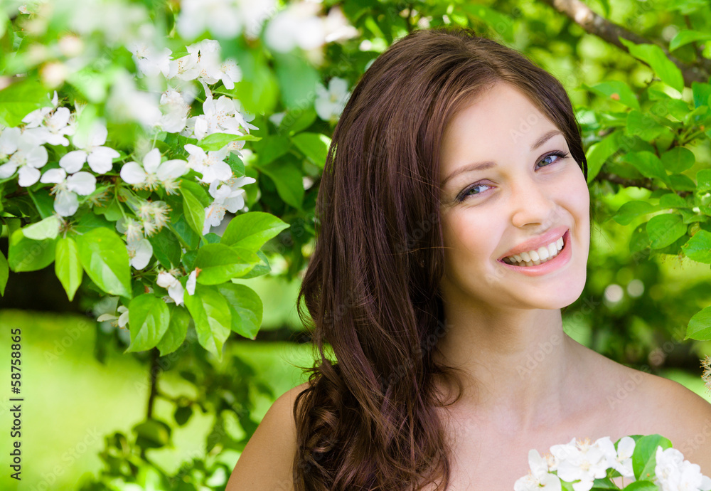 Portrait of young woman near the flowered tree in the park Portrait of young woman near the flowered tree in the park