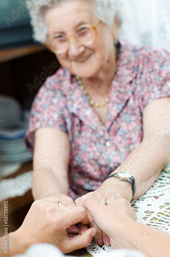 Young hand holding an elderly pair of hands