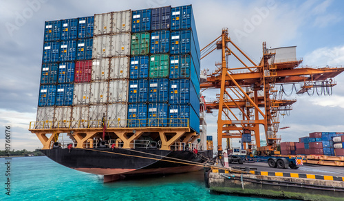 Container Cargo freight ship with working crane loading