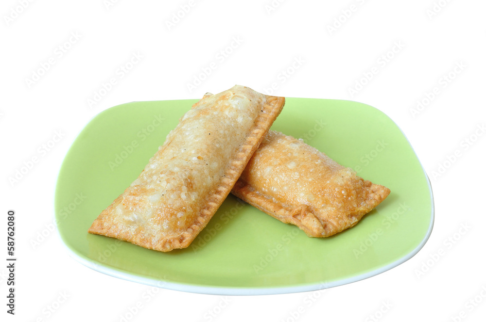 Crispy pies on green plate isolated white background.