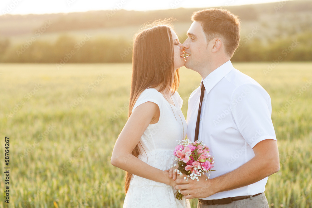 just married couple kissing on the sunset in the field just married couple kissing on the sunset in the field