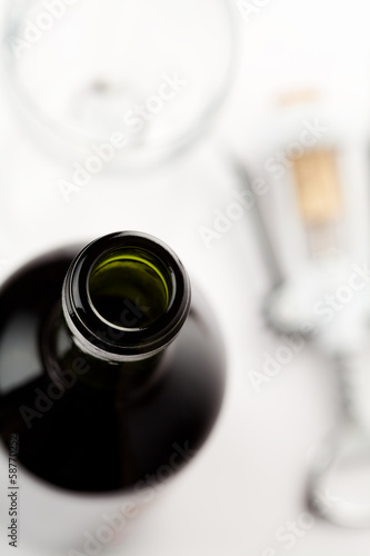 Close up of wine bottle with corkscrew and glass
