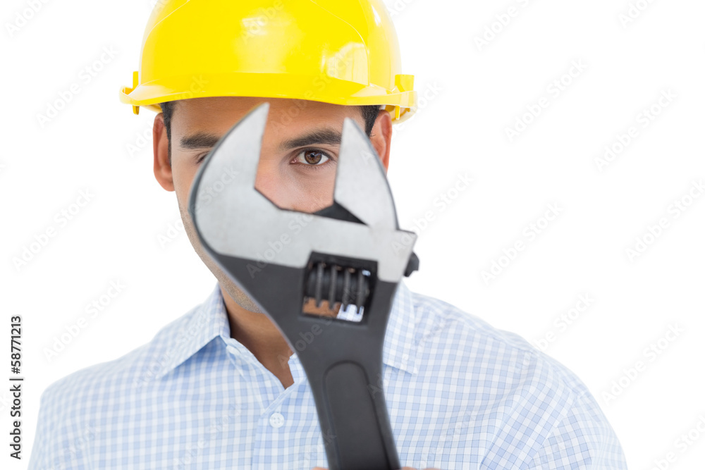 Close-up portrait of a young handyman with a wrench