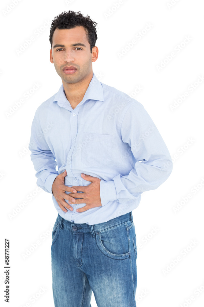 Portrait of a casual young man with stomach pain Portrait of a casual young man with stomach pain